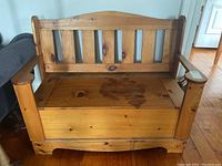 Front full view of cedar wood bench showing hinged seat with visible knob and solid armrests.