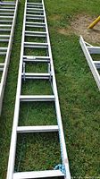 Top half view of 24 ft aluminum extension ladder showing multiple rungs and blue rope pulley.