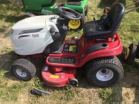 Front side view of tractor showing white hood, red body, black seat, mower deck and front wheels