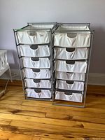Front view photo showing two storage units side-by-side with six white fabric drawers each and silver metal frames.