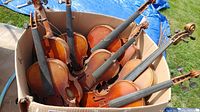 Overhead view of eight violins packed in cardboard box
