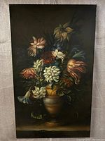 Full view showing dark background and floral bouquet in urn