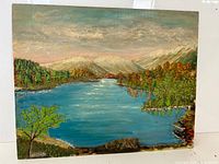 Full view of the signed landscape oil painting on board showing lake, forest, mountains, and sky