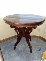 Full side view of antique round side table showing wood finish and leg details