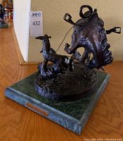 Three-quarter front view of bronze sculpture on marble base