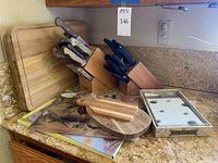 Overview of two knife blocks with assorted knives, multiple wood cutting boards and a boxed Swiss cheese board