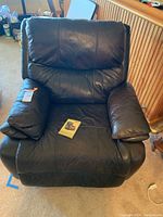 Front view of dark brown leather recliner chair showing padded arms, seat, and backrest.