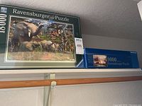 Two Ravensburger puzzle boxes side by side: one 9000 piece and one 18000 piece wildlife puzzle.