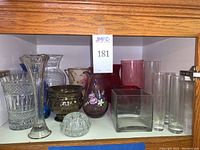 Photo showing entire collection of assorted glass vases in varying colors and styles including cut, frosted, painted and colored glass.
