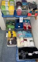 Overview photo showing multiple bins stacked on carpet with yarn skeins in various bright colors