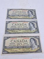 Three 1954 Canadian $20 bills laid flat showing obverse sides
