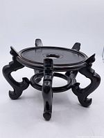 Full view of vintage Chinese hardwood jardiniere stand showing curved carved legs and round top with central hole