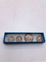 Overhead view of all four coins in a blue presentation box
