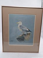 Full view of the framed print showing the seagull artwork within a beige mat and light frame.