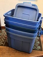 Stack of Rubbermaid totes with lids on top showing the size and shape of the large tote and some smaller ones inside.