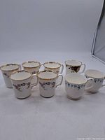 Photo showing all 8 mugs together with various floral and gold designs.