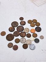 Overview of 24 assorted vintage and antique coins on white background