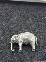 Small hollow sterling silver elephant figurine with visible patina and markings.
