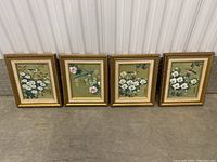 Four framed paintings with Asian floral and bird themes, arranged side by side on floor