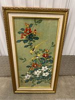 Framed Asian-style bird and flower painting showing two yellow long-tailed birds with red and white flowers on green background.