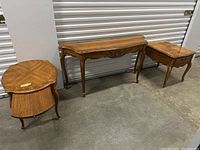 Three French court style wooden tables positioned against wall, showing full set