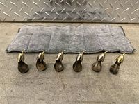 Photo showing all six eggplant figurines lined up on a gray padded cloth.
