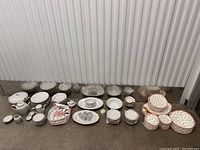Full overview of the vintage porcelain dinnerware set including multiple stacks of plates, cups, bowls, serving items, and boxes of floral patterned porcelain items.