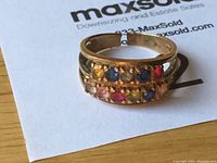 Front view of ring showing row of colored stones