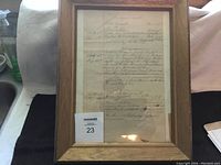 Full view of one framed judgment deed showing wood frame and aged paper with handwriting