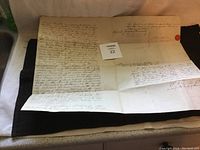 Photo of the 1903 handwritten land deed showing handwritten cursive legal text and a red wax seal on large aged paper.