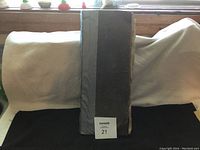 Full front view of the closed large antique ledger book showing its thick spine, reinforced with tape along the spine, and worn cover.