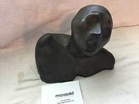 Front and right-side profile view of abstract bronze bust on cloth with MaxSold card.