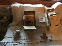 Overview of three Calico kitten statues in boxes on a cloth background, showing condition and packaging.