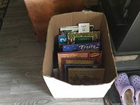Box full of assorted vintage children's books viewed from the top, showing several colorful book titles and covers.