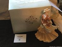 Figurine standing next to original box with Coalport logo on the box.