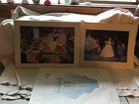 Both lithographs shown side by side, featuring Snow White with dwarfs and Cinderella with carriage
