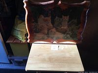 Wood tray showing five kittens sitting in flowers, photographed from above in light.