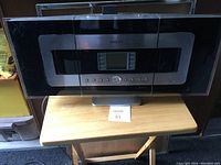 Full frontal view of the Philips Streamium music system showing the screen and control buttons on a silver metal base.