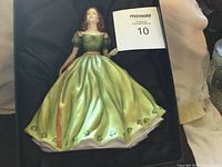 Front view of the Royal Doulton Irish Charm figurine in box, showing full figure of woman in green dress with orange sash