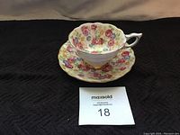 Royal Stafford antique teacup and saucer set with floral June Roses pattern, gold accents, shown front angle.