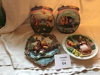 Four 3D Winnie the Pooh collector plates arranged on fabric surface showing characters Pooh, Tigger, Eeyore, Rabbit, Piglet. Plates show visible signs of wear and some discoloration.