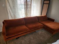 Front view of burnt orange velvet sectional sofa showing full length