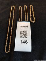 All four 10kt gold rope chain pieces laid out on black background