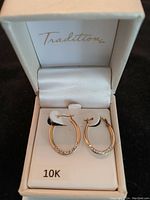 Pair of small to medium 10K gold hoop earrings with crystal details displayed in original Tradition box marked 10K.