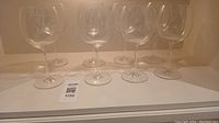 Photo showing 8 clear red wine glasses arranged in two rows with stems visible, taken to display quantity and condition.