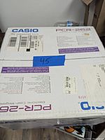 Top view of the Casio PCR-262 electronic cash register box showing model number and packaging details.