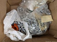 Box containing bagged metal chains, including some chains with hooks and other hardware attachments