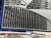 Close-up of a drill bit set with many bits in size order, shiny and unused.