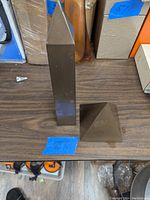 Obelisk and pyramid figurines side by side on a table, showing relative size and shape.
