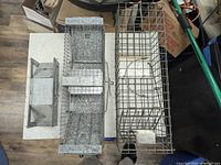 Three metal live animal traps on a table, showing sizes and structure